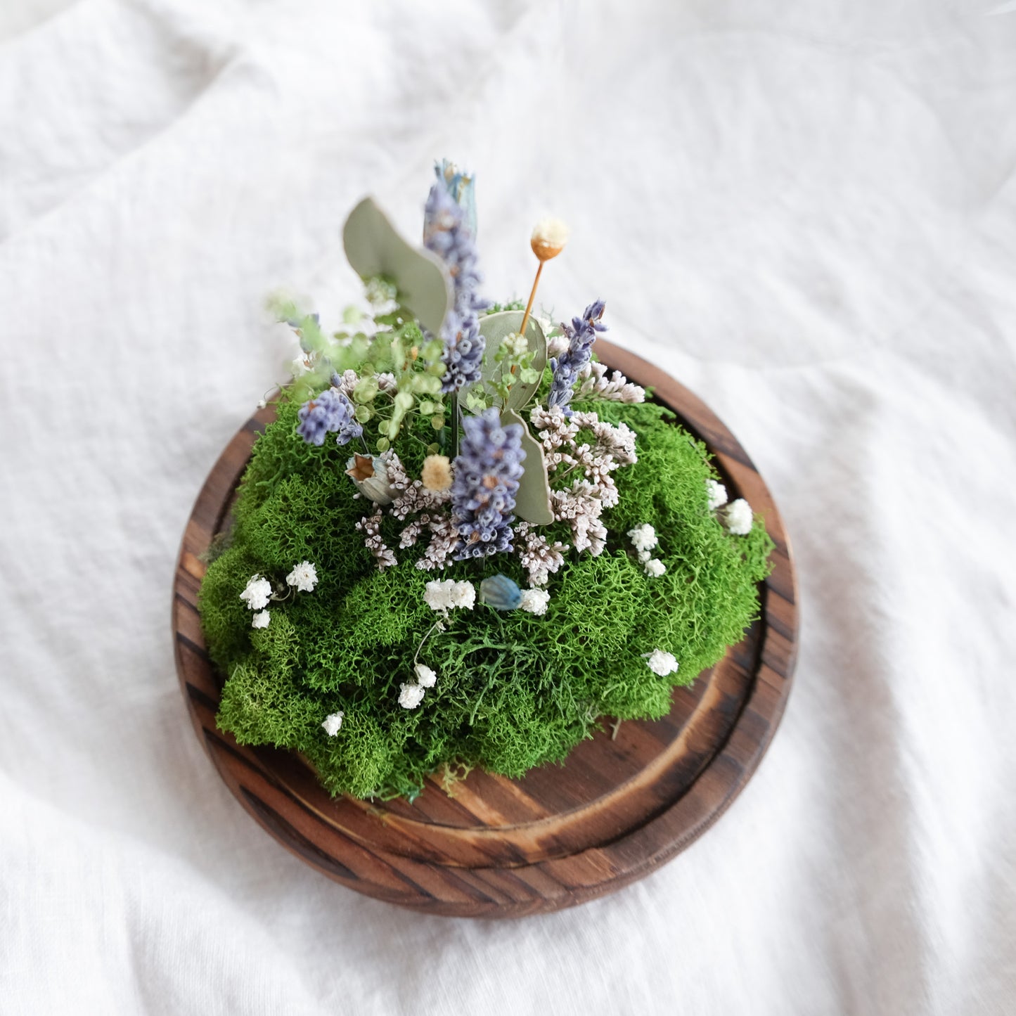 terrarium with moss, lavender, and dried botanicals